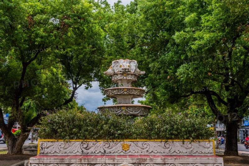 Ornate fountain in a park setting surrounded by lush green trees, in Chiang Mai, Thailand, Asia