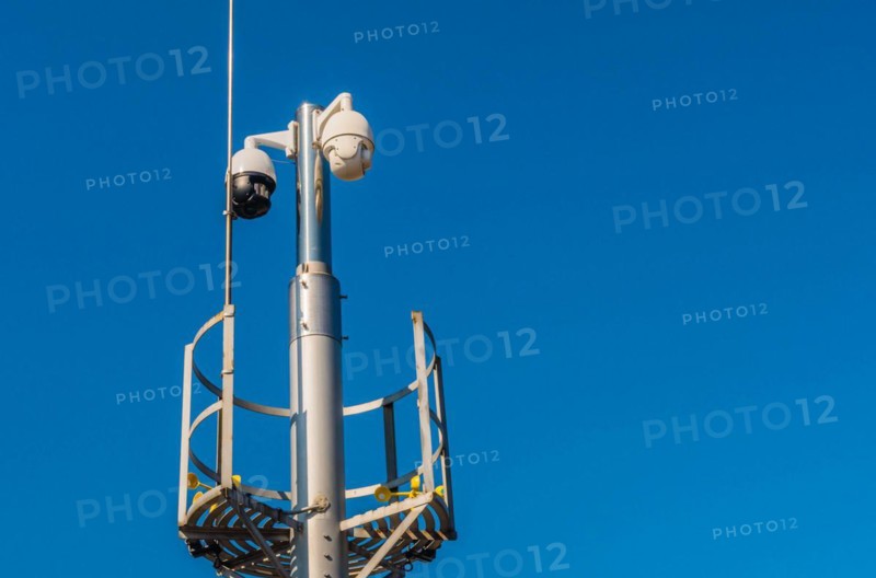 Closed circuit television devices and weather veins on metal pole against blue sky in Daejeon, South Korea, Asia