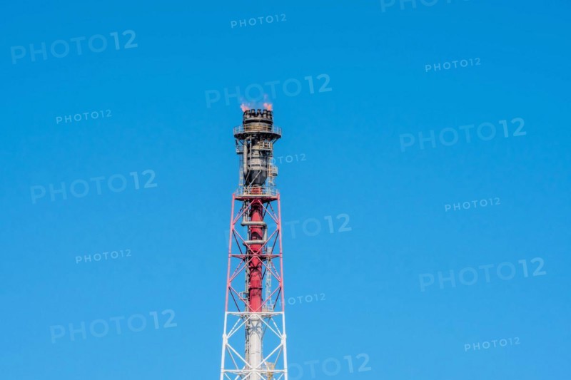 Blue sky backdrop with a fierce flame atop an industrial flare stack, in Ulsan, South Korea, Asia