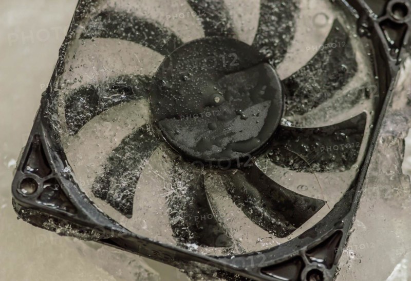 Closeup of computer case fan frozen in block of ice. Concept keep your computer cool