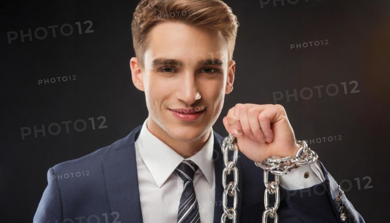 Smiling man in suit with chains on his hand represents a symbolic liberation from shackles, symbol office, AI generated, AI generated