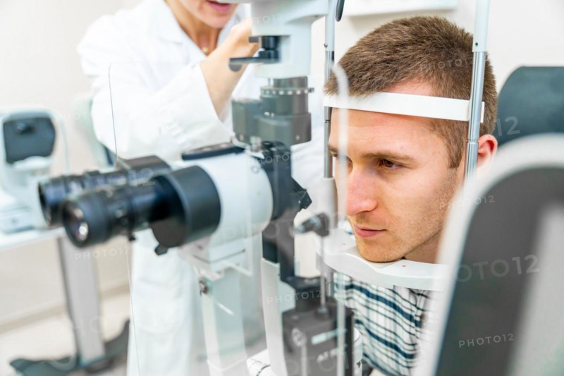 Man having his eyes checked at ophthalmologist by a female doctor