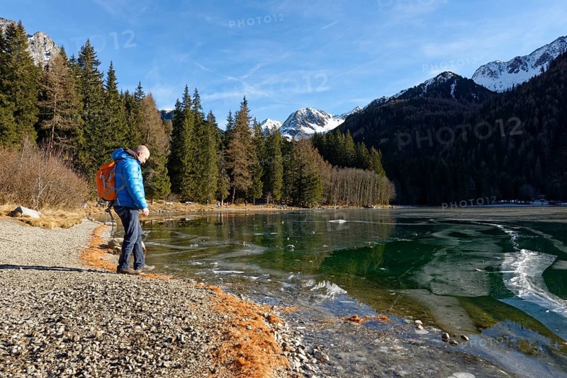 Hikers in winter on an icy lake, Lake Antholz in the Antholz Valley, Val Pusteria, South Tyrol, Italy, Europe