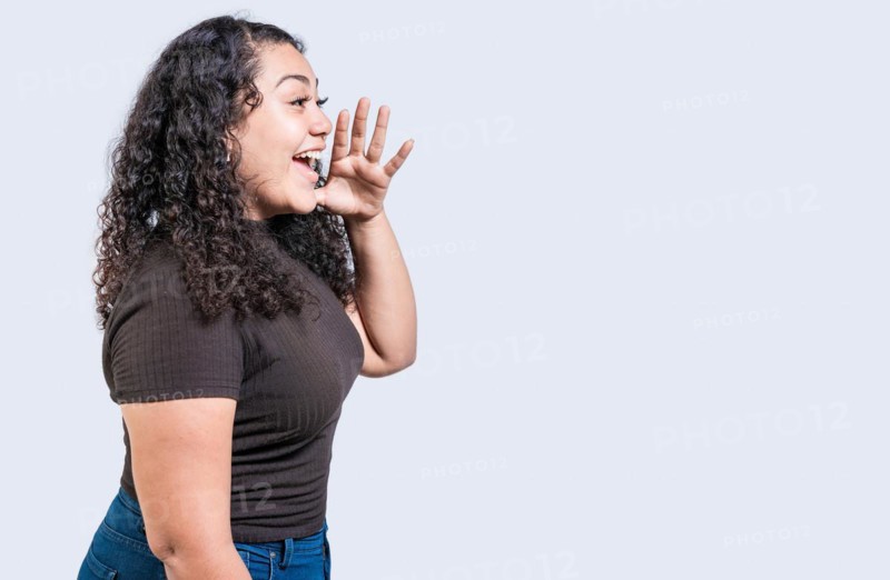Happy girl announcing something isolated. Beautiful woman screaming and announcing an advertising isolated