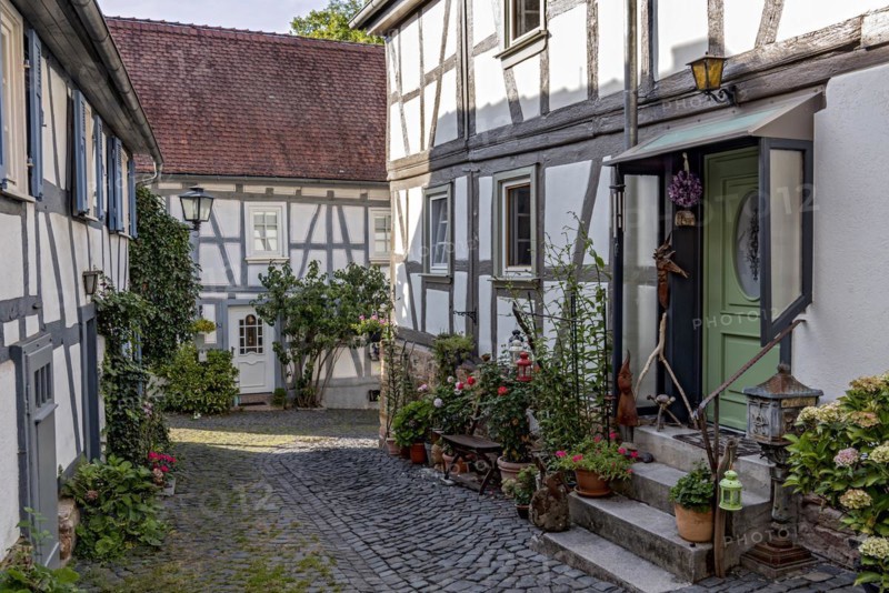 Old half-timbered houses, decorated with flowers, idyllic alley, old town, Ortenberg, Vogelsberg, Wetterau, Hesse, Germany, Europe