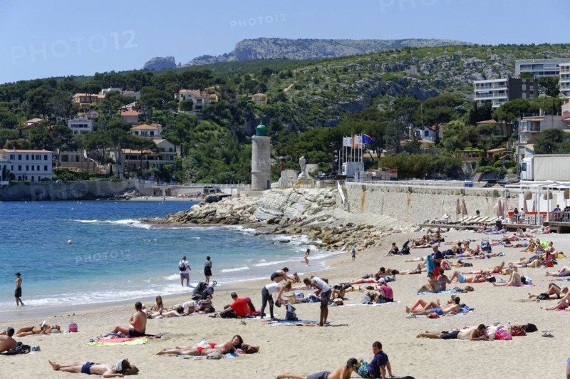 The bay of Port Miou in Cassis, people sunbathing on the beach with a view of the sea and nature, Marseille, Departement Bouches-du-Rhone, Region Provence-Alpes-Cote d'Azur, France, Europe