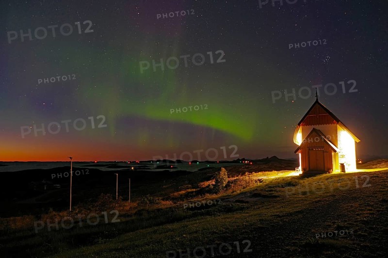 Northern lights (aurora borealis) merging with sunset, Petter Dass Chapel, night shot, Lovunden, Helgeland coast, Traena, Norway, Europe