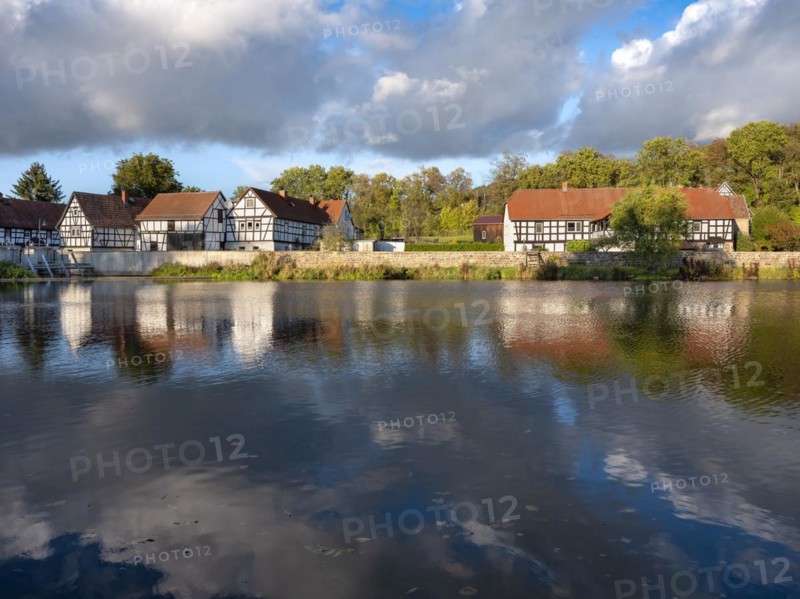Half-timbered houses are reflected in the river Weisse Elster, Wuenschendorf (Elster), Thuringia, Germany, Europe