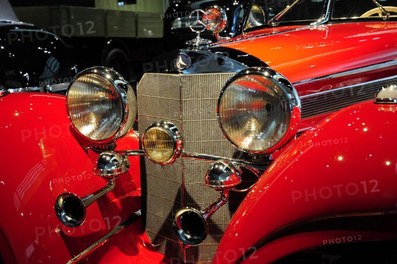 Front view of a red classic car with shiny headlights and chrome accents, Mercedes-Benz Museum, Stuttgart, Baden-Wuerttemberg, Germany, Europe