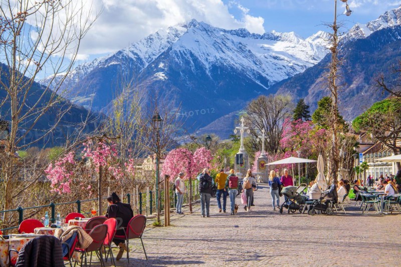 Winter promenade along the river Passer with street cafe in the background the Texel Group with the peak 3006m in spring, Merano, Pass Valley, Adige Valley, Burggrafenamt, Alps, South Tyrol, Trentino-South Tyrol, Italy, Europe