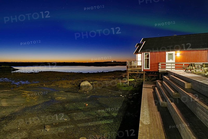 Red building with balcony by the water, Northern lights (aurora borealis), Rorbuer, holiday, accommodation, Lovund, Lovunden, Helgeland coast, Norway, Europe