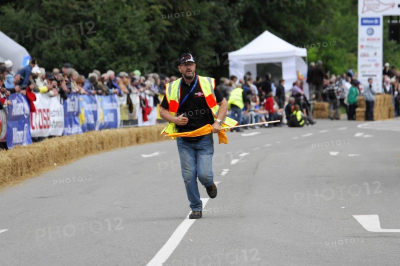 A person in a yellow safety waistcoat runs across a race track with a flag, SOLITUDE REVIVAL 2011, Stuttgart, Baden-Wuerttemberg, Germany, Europe