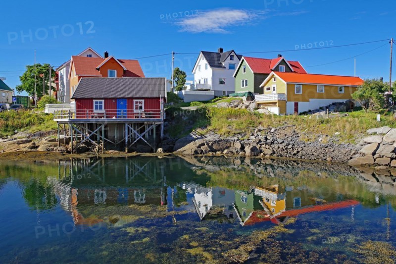 Small, colourful fishermen's houses are reflected in the calm waters of a small harbour, Rorbuer, holiday, Henningsvaer, Nordland, Lofoten, Norway, Europe