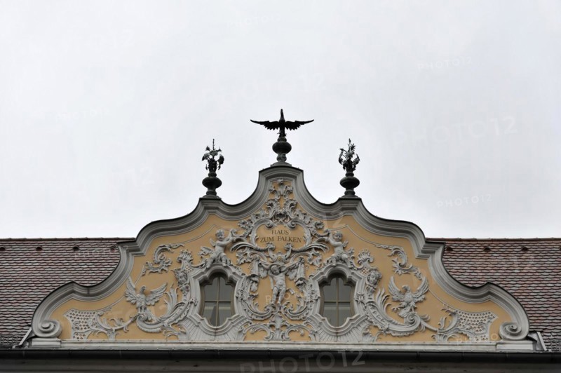 Facade view of the Falkenhaus with stucco facade in rococo style in the centre of Wuerzburg, Baroque facade with elaborate stucco work and an eagle on the roof peak under a grey sky, Wuerzburg, Lower Franconia, Bavaria, Germany, Europe
