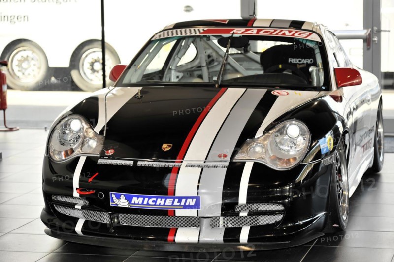 A black Porsche racing car with white and red stripes stands in the showroom, Schwaebisch Gmuend, Baden-Wuerttemberg, Germany, Europe