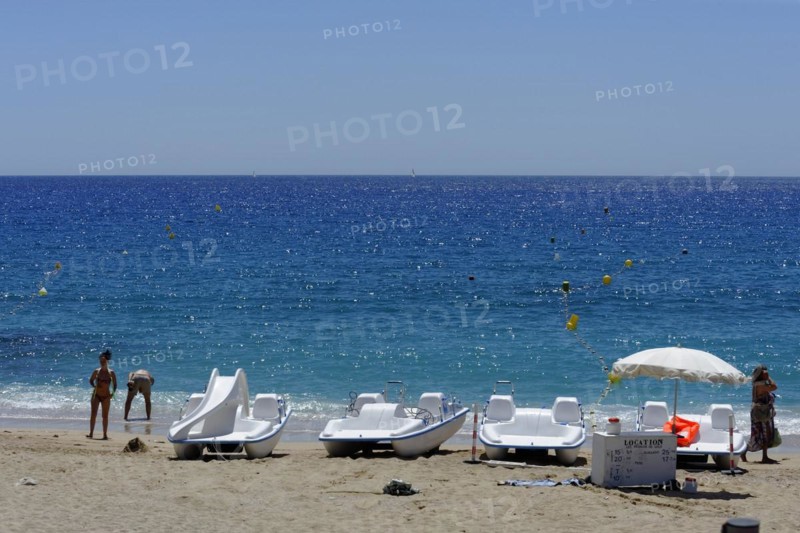 The bay of Port Miou in Cassis, A sunny beach day with people, sunbathing boats and clear blue sea, Marseille, Departement Bouches-du-Rhone, Region Provence-Alpes-Cote d'Azur, France, Europe