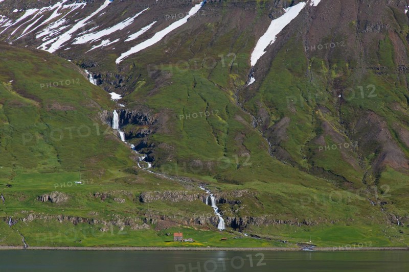Waterfall and desolate farm along the fjord Seyoisfjoerour, Seydisfjoerdur in summer, Eastern Region, Austurland, Iceland, Europe