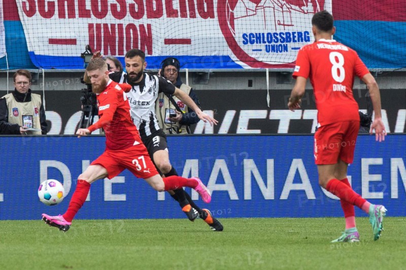 Football match, Jan-Niklas BESTE 1.FC Heidenheim left takes a shot, Franck HONORAT Borussia Moenchengladbach tries to stop him, Eren DINKCI 1.FC Heidenheim right watches the scene, Voith-Arena football stadium, Heidenheim