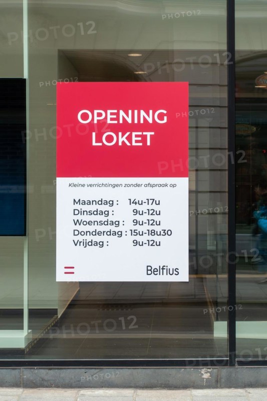 Office window showing opening hours of Belfius bank branch in the city Ghent, East Flanders, Belgium, Europe