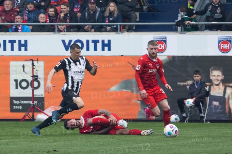 Football match, Stefan LAINER Borussia Moenchengladbach left pursues Jan-Niklas BESTE 1.FC Heidenheim while Tim KLEINDIENST 1.FC Heidenheim rolls on the ground after a foul, football stadium Voith-Arena, Heidenheim