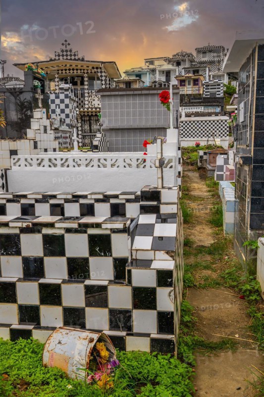 Famous cemetery, many mausoleums or large tombs decorated with tiles, often in black and white. Densely built buildings under a sunset Cimetiere de Morne-a-l'eau, Grand Terre, Guadeloupe, Caribbean, North America