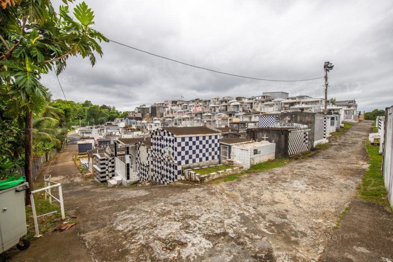 Famous cemetery, many mausoleums or large tombs decorated with tiles, often in black and white. Densely built buildings under a dramatic cloud cover Cimetiere de Morne-a-l'eau, Grand Terre, Guadeloupe, Caribbean, North America