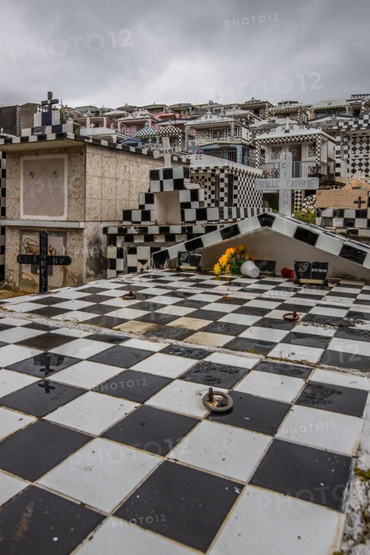Famous cemetery, many mausoleums or large tombs decorated with tiles, often in black and white. Densely built buildings under a dramatic cloud cover Cimetiere de Morne-a-l'eau, Grand Terre, Guadeloupe, Caribbean, North America