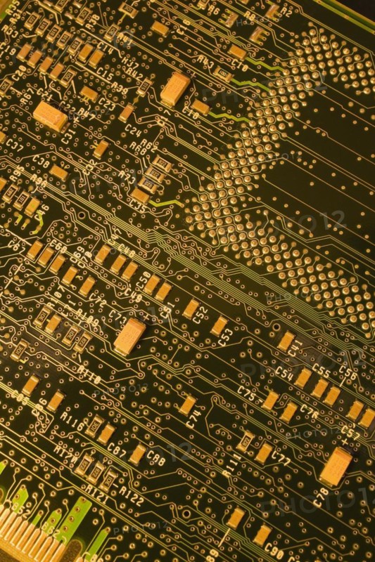 Close-up of dark green and golden yellow lighted electronic computer circuit board with lines and silver solder points, Studio Composition, Quebec, Canada, North America