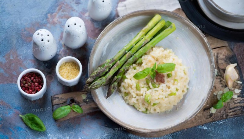 Risotto with asparagus arranged in a plate, surrounded by spices, risotto with green asparagus, KI generated, AI generated