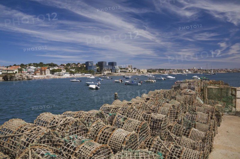 Commercial crab fishing cages and moored boats in the harbour at Cascais, Portugal, Europe