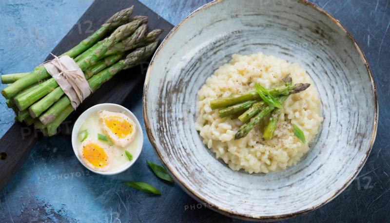 Creamy risotto with asparagus and a poached egg, served on wood, risotto with green asparagus, KI generated, AI generated
