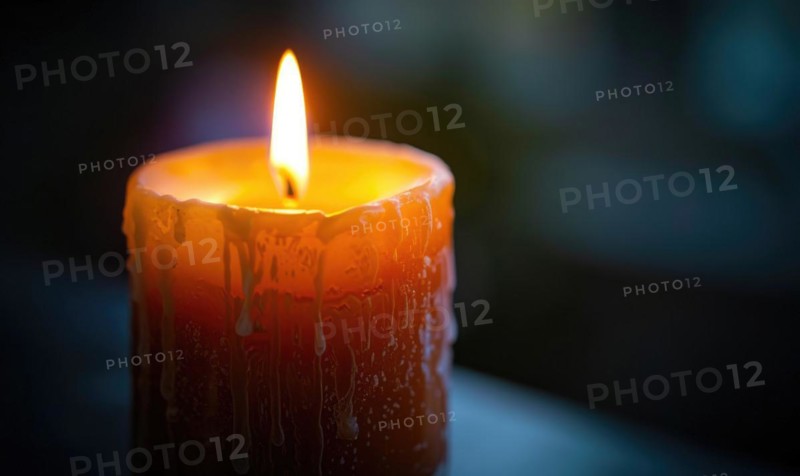Close-up of a candle's gentle flicker illuminating a serene setting AI generated