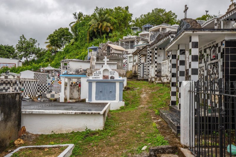 Famous cemetery, many mausoleums or large tombs decorated with tiles, often in black and white. Densely built buildings under a dramatic cloud cover Cimetiere de Morne-a-l'eau, Grand Terre, Guadeloupe, Caribbean, North America