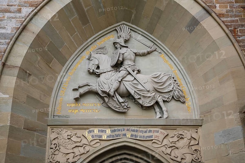 Eagle Gate, stone relief on the outer castle gate, knight figure on horse, armour, inscription, Hohenzollern Castle, ancestral castle of the Prussian royal and German imperial dynasty of Hohenzollern, summit castle, historic building by the Berlin architect Friedrich August Stueler, architecture, neo-Gothic, castle building, aristocratic residence, Bisingen, Zollernalbkreis, Baden-Wuerttemberg, Germany, Europe
