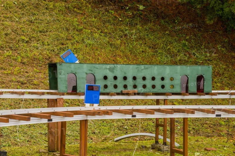 Close-up of a miniature railway track segment with circular holes and blue signs, in South Korea