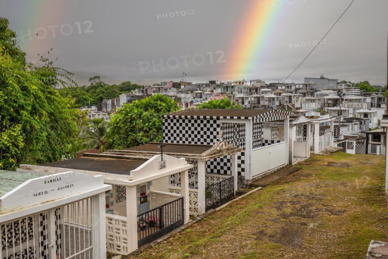 Famous cemetery, many mausoleums or large tombs decorated with tiles, often in black and white. Densely built buildings under a dramatic cloud cover Cimetiere de Morne-a-l'eau, Grand Terre, Guadeloupe, Caribbean, North America