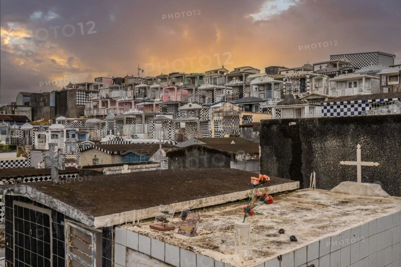 Famous cemetery, many mausoleums or large tombs decorated with tiles, often in black and white. Densely built buildings under a sunset Cimetiere de Morne-a-l'eau, Grand Terre, Guadeloupe, Caribbean, North America