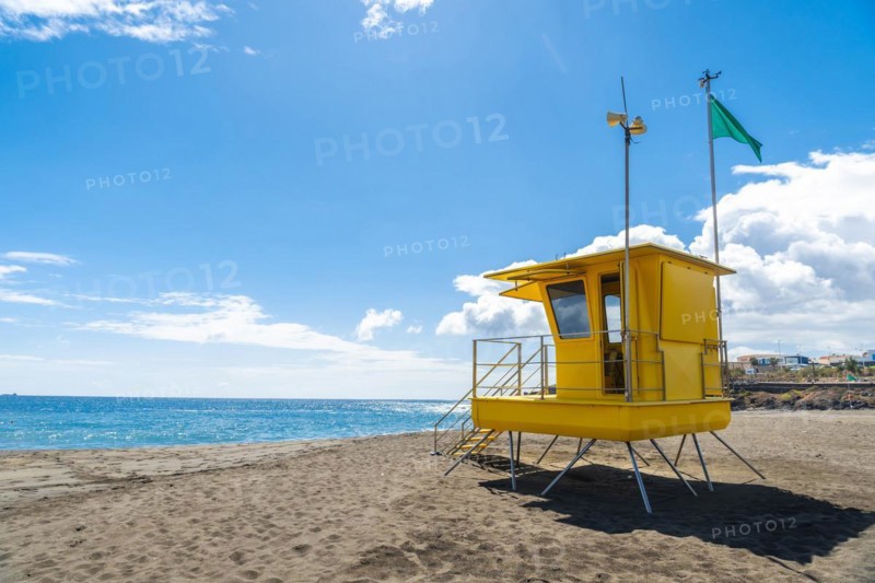 Yellow lifeguard tower in California with green flag
