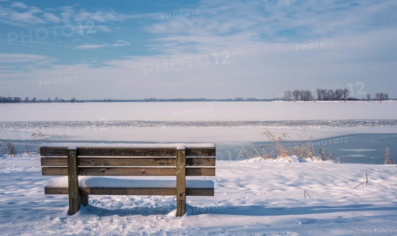 A snow-covered bench overlooking the frozen expanse of a lake AI generated