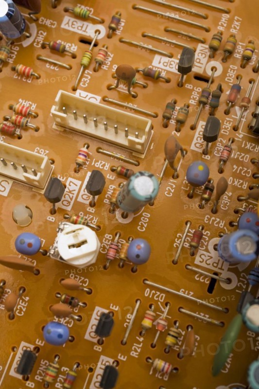 Close-up of orange electronic computer circuit board with capacitors and transistors, Studio Composition, Quebec, Canada, North America