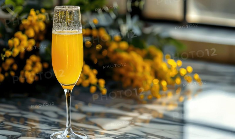 Cocktail in a glass goblet with mimosa branches in the background AI generated