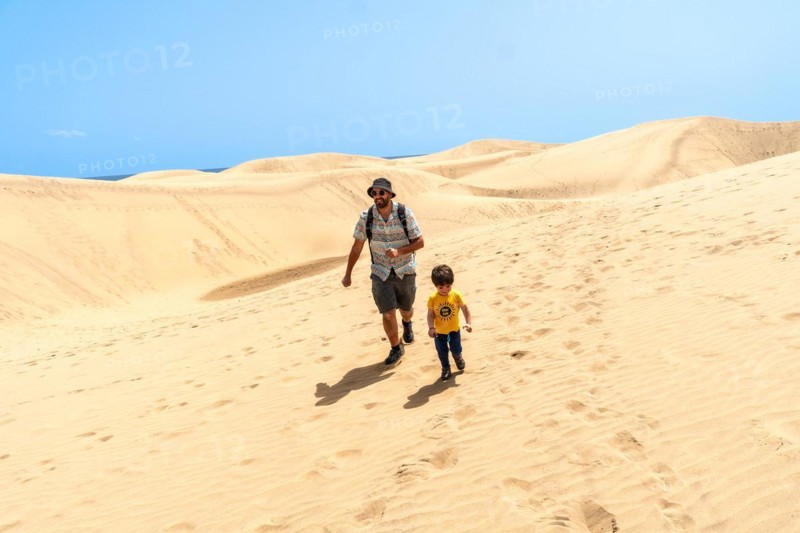 Father and son on vacation laughing running in the dunes of Maspalomas, Gran Canaria, Canary Islands