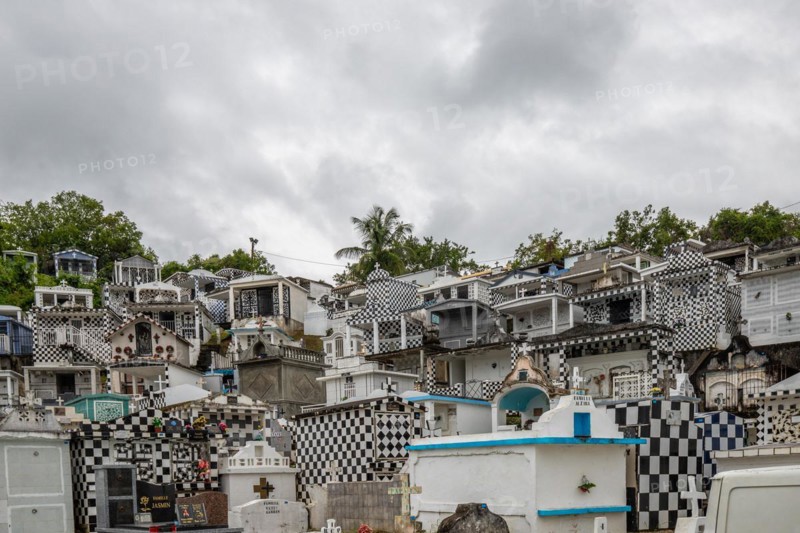 Famous cemetery, many mausoleums or large tombs decorated with tiles, often in black and white. Densely built buildings under a dramatic cloud cover Cimetiere de Morne-a-l'eau, Grand Terre, Guadeloupe, Caribbean, North America