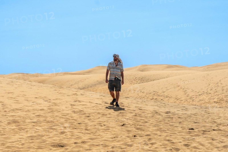 Tourist man with turban in summer walking in the dunes of Maspalomas, Gran Canaria, Canary Islands