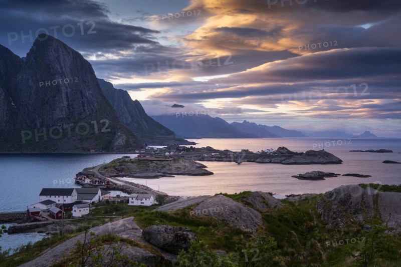 Landscape on the Lofoten Islands, view of Toppoya, Hamnoy and the sea, along Moskenesoya, Flakstadoya and Vestvagoya. Several coloured lenticular clouds (lenticularis) in the sky. At night at the time of the midnight sun. Early summer. Moskenesoya, Lofoten, Norway, Europe