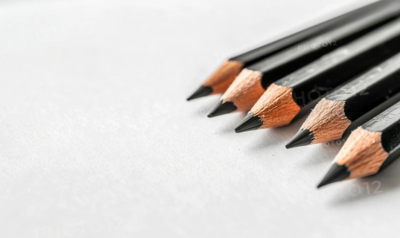 Graphite pencils lying on a blank sheet of white paper AI generated