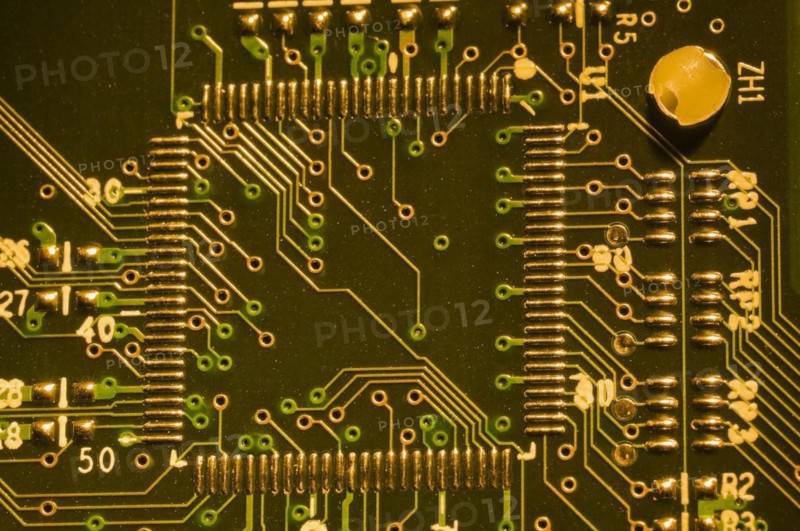 Close-up of microchip, silver solder points and lines on golden lighted electronic computer circuit board, Studio Composition, Quebec, Canada, North America