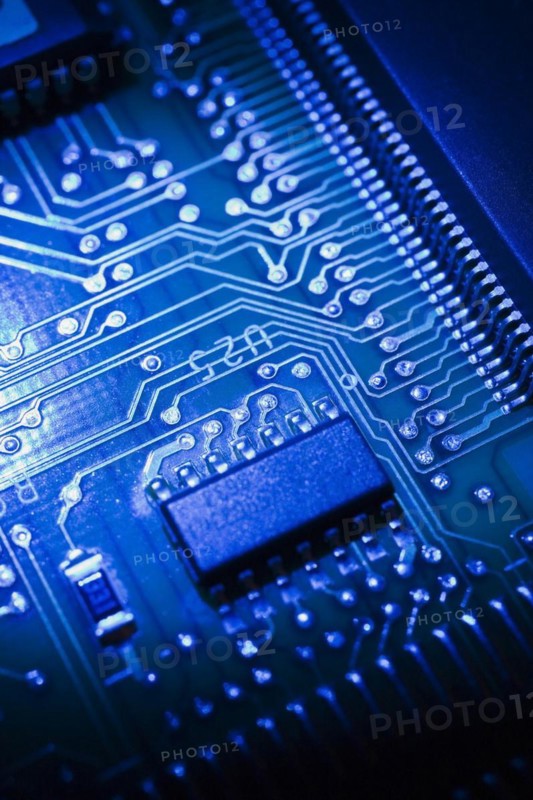 Close-up of blue lighted electronic computer circuit board with microchip, silver solder points and lines, Studio Composition, Quebec, Canada, North America