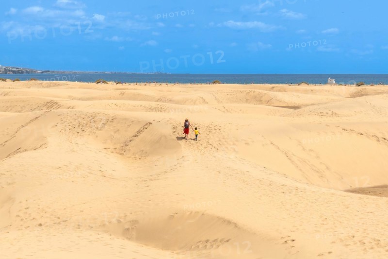 Mother and child walking on summer holidays in the dunes of Maspalomas, Gran Canaria, Canary Islands