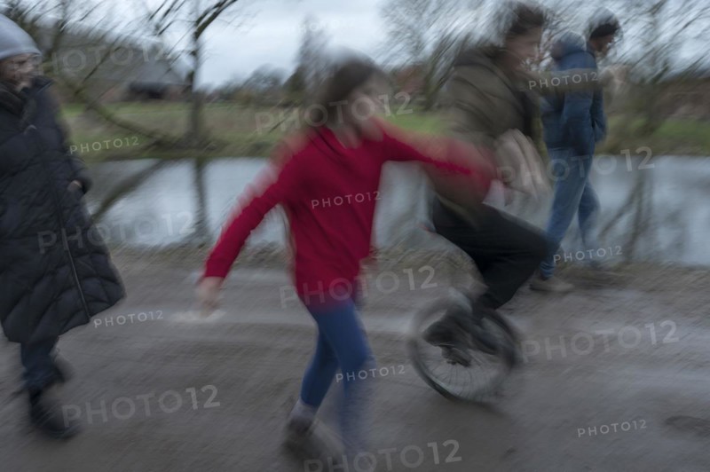 Family walk, a young woman with a unicycle, motion blur, Mecklenburg-.Vorpommern, Germany, Europe
